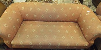A late Victorian Chesterfield sofa on bun front feet, upholstered in terracotta foliate patterned