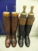 A pair of brown leather field boots with wooden trees by Victor Gilpin and a pair of black and brown