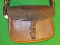 A pigskin 150 piece cartridge bag with canvas strap, bearing initials "W.H.St.
