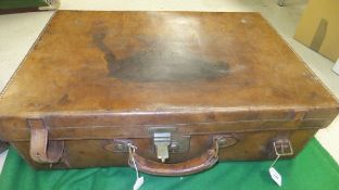 A vintage leather suitcase stamped "50 Army & Navy CSL Makers London"