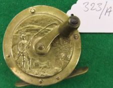 An un-named 21/4" diameter crank wind reel with side plates decorated with an embossed fishing