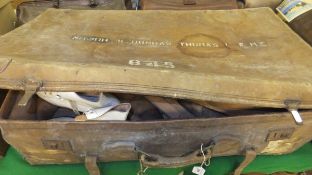 A leather trunk containing various boot trees and a pair of vintage ice skates,