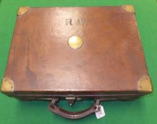A brass-bound leather cartridge magazine, the lid bearing initials "R.W.