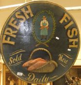 A circular hand-painted wooden advertising board for "Fresh Fish" with relief decoration