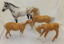 A selection of four Beswick horse figures to include one piebald and three palomino