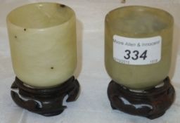 A pair of Chinese jade beakers CONDITION REPORTS Beakers attached to bases. Some chips to the