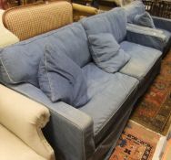 A modern upholstered three seat sofa and matching armchair with denim loose covers