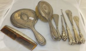 A silver backed hand mirror and matching brush,