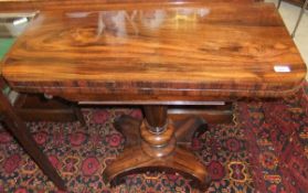 An early Victorian rosewood card table, the rectangular foldover top opening to reveal a circular