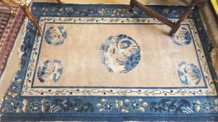 A Chinese rug, the central bird decorated medallion in shades on blue, cream and black on a mushroom