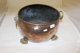 A Victorian copper and brass embellished coal container with lion mask ring handles on lions paw