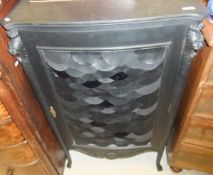 A black painted serpentine fronted single door cupboard enclosing four drawers,