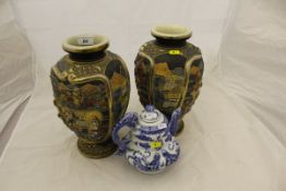 A pair of early 20th Century Japanese Satsuma ware vases with figural decoration in relief and a