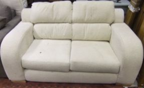 A modern cream upholstered two seat sofa