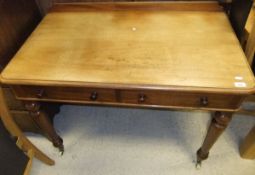 An Edwardian mahogany two drawer desk on turned legs to white china castors,