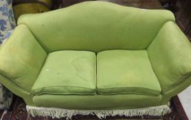 A camel back sofa upholstered in lime green fabric