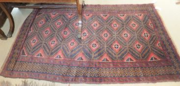 A Caucasian rug, the repeating diamond shaped linked lozenge medallions in pale red, madder,
