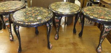 A set of four floral painted and ebonised circular stools