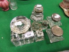 A collection of glass and glass and silver mounted inkwells to include a heavy glass cuboid inkwell,