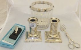 A pair of Victorian silver dwarf candlesticks with engraved floral sway decoration raised on