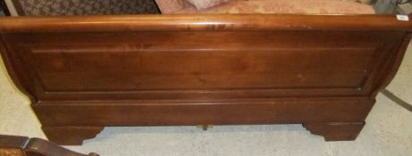 A modern cherrywood sleigh bed in the 19th Century French manner
