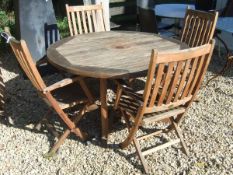 A Barlow Tyrie teak garden table and six folding chairs with cushions,