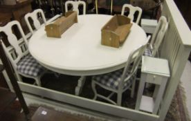 A modern painted circular pedestal dining table on carved quatrefoil base,