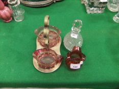 A small cranberry glass vase with flared rim, a cut glass scent bottle/decanter,