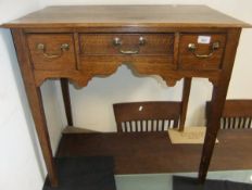 A circa 1800 oak lowboy with three frieze drawers on square tapering supports