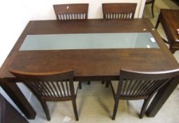 A modern mahogany dining table and set of four comb back chairs with upholstered seats