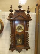 A walnut cased Vienna regulator type wall clock, the enamelled chapter ring bearing Roman numerals,