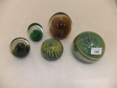 A large Mdina glass paperweight, a smaller version, and three Whitefriars paperweights with internal