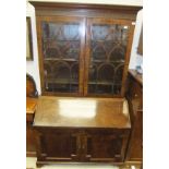 An early 19th Century mahogany bureau bookcase with blind fretwork to the cornice enclosing shelves,