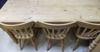 A modern pine farmhouse style kitchen table and set of six stained beech slat back kitchen chairs