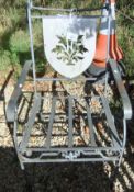 An iron garden elbow chair with shield shaped and pierced back