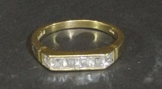 An 18 carat gold dress ring set with six square cut diamonds, approx 0.