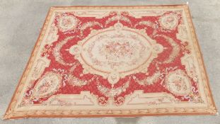 An Aubusson style rug with central floral medallion on a cream ground,