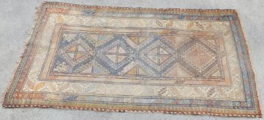 A Caucasian rug, the four central diamond shaped medallions in shades of salmon, madder and blue,