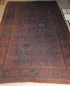 A Beluch village tribal carpet, the centrefield with stylised floral motifs in red,