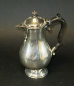 A George V silver baluster shaped water jug with ebonised handle,
