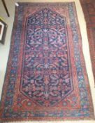 A Caucasian rug, the centrefield with stylised floral and foliate motifs in red, mid blue and