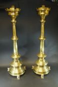 A pair of Victorian weighted brass Gothic Revival candlesticks with castellated drip trays on