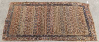 A Caucasian rug, the beige ground with all-over repeating hook medallions in cinnamon, terracotta,