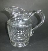 An Irish cut glass water jug with horizontal ribbing to lip and neck, and semi facet cut sides,