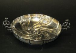 A silver pedestal bowl with embossed wrythen decoration and figural decorated openwork handles,