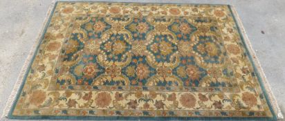 An Oriental rug, the centrefield with all-over stylised floral and foliate motifs in eau de nil,