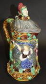 A Minton Majolica "Tower" flagon with jester mask knop to the pewter hinged scallop shell lid over