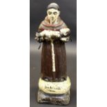 An 18th Century North Italian carved wood and polychrome decorated figure of a monk holding a baby