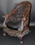 A 19th Century Anglo-Indian heavily carved rosewood framed armchair, the yoke back with all over