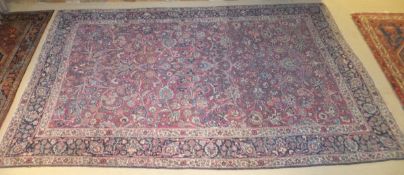 A Persian carpet, the all-over stylised floral and foilate decoration on a red ground within dark